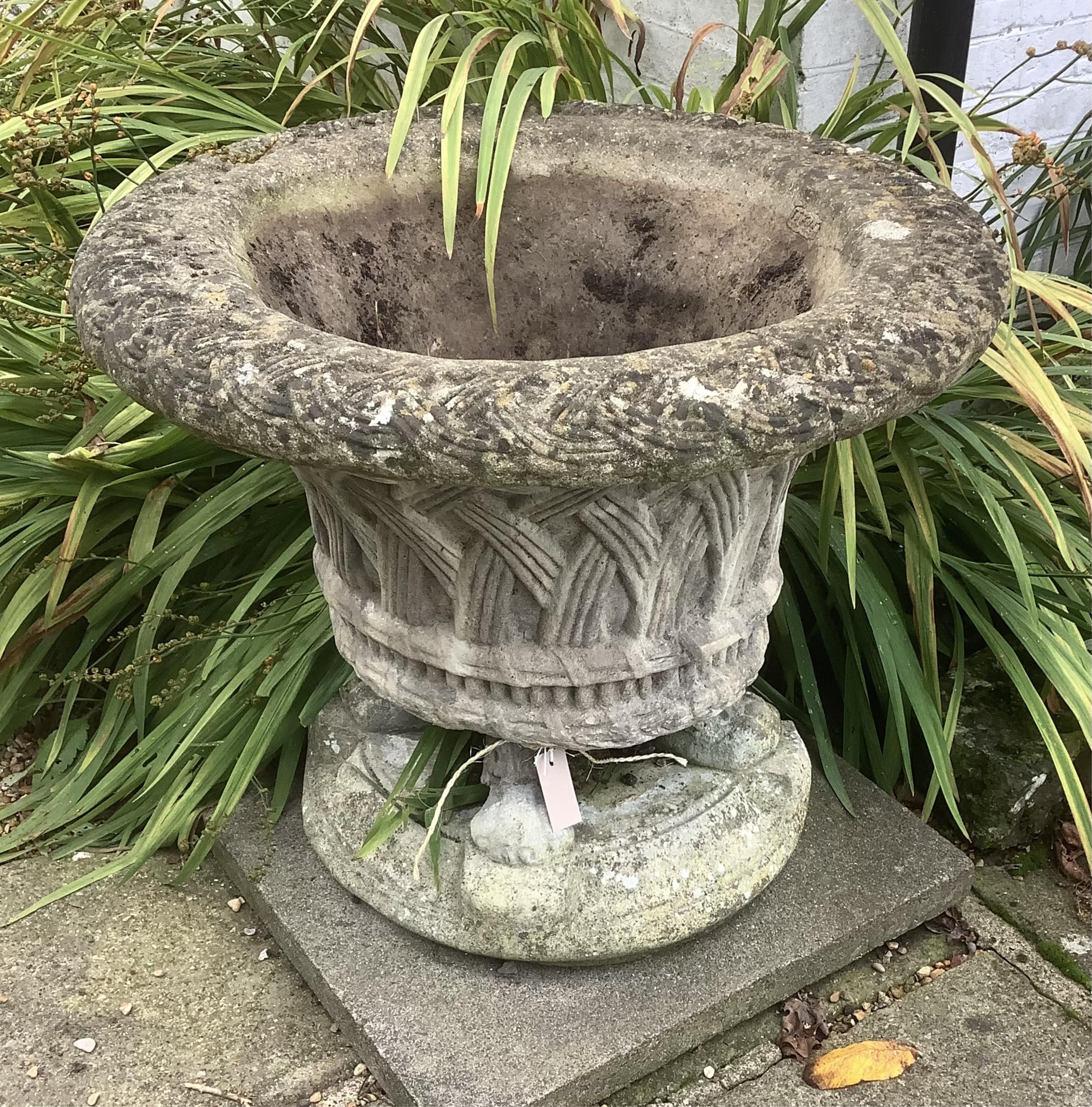 A reconstituted stone basket urn on stand, height 76cm, depth 60cm. planting removed, Condition - weathered, otherwise good